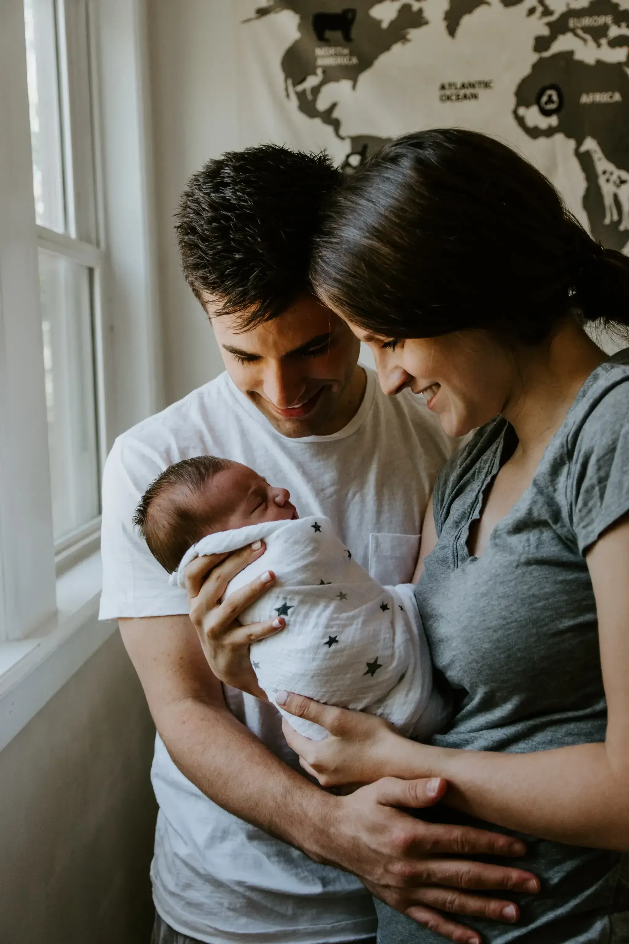 Parents holding their newborn in a warm home setting